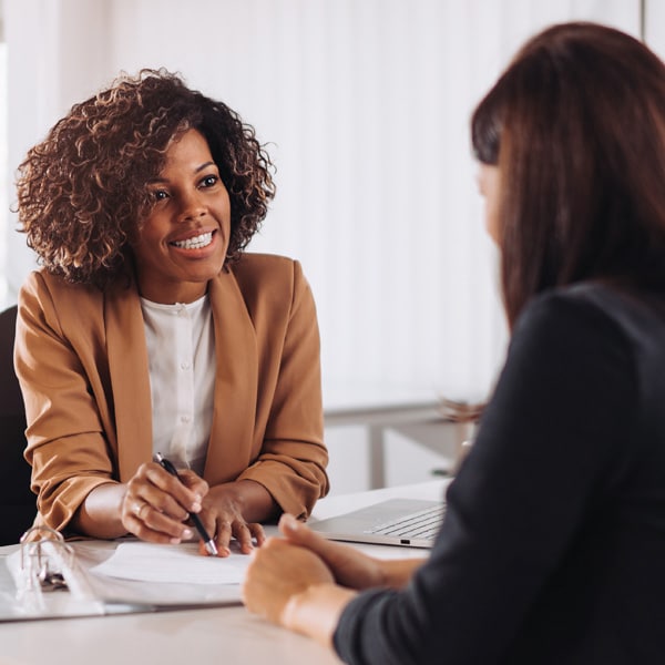 Two women talking at a desk