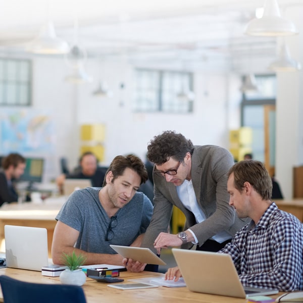 Three people looking at a tablet