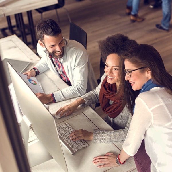 Three people looking at a computer.