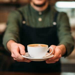 Person handing over a cup of coffee