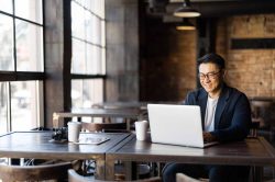 man in coffee shop using advanced web protection on his computer