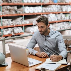 Picture of a man in a warehouse with a computer