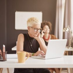 Picture of women at desks looking at computers